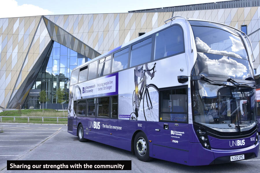 A bus parked in front of a building showing BU's communications to the region
