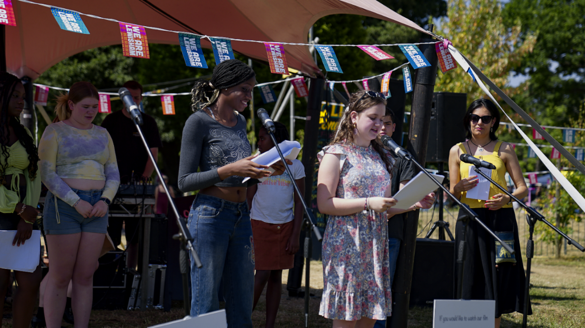 Park Life Project at Lewisham People's Day - two people stood at microphones reading from sheets of paper.