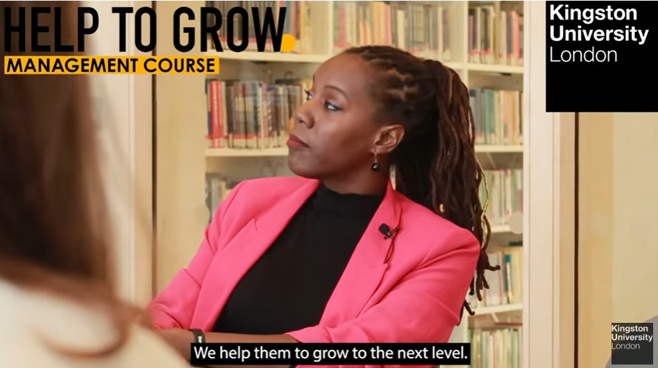 Link to video of Help to Grow Management Course. Screenshot of female participant in front of shelves of books.