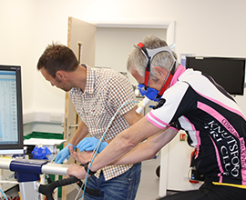 Photo of man on exercise bike being monitored by Sports Science academic