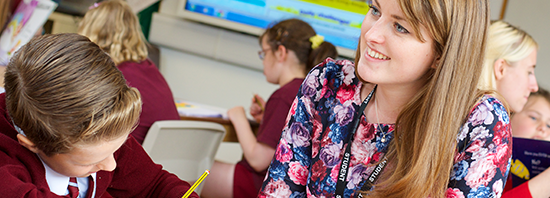 Photo of classroom with school teacher and pupils