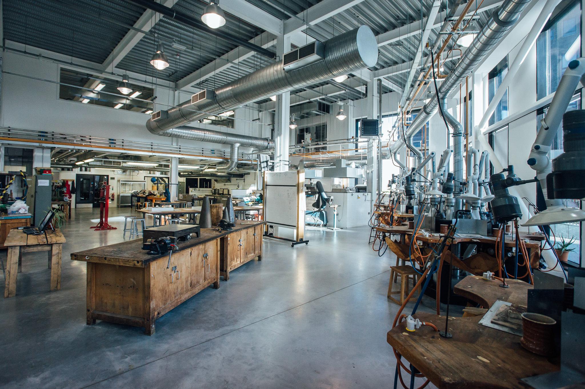 An image of the interior of a crafts studio in Arts University Plymouth. The image shows making and jewellery work benches in an industrial style workshop setting.