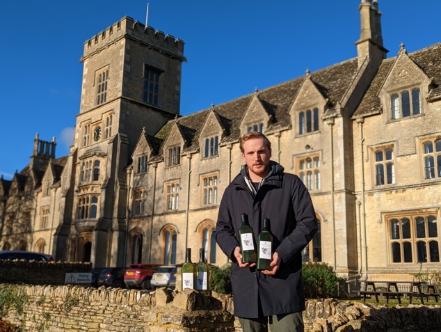 A student with bottles of the new Cotswold Hills flat wine bottles outside the front of the RAU building