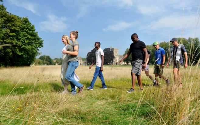 A group of people walking in a field Description automatically generated with medium confidence