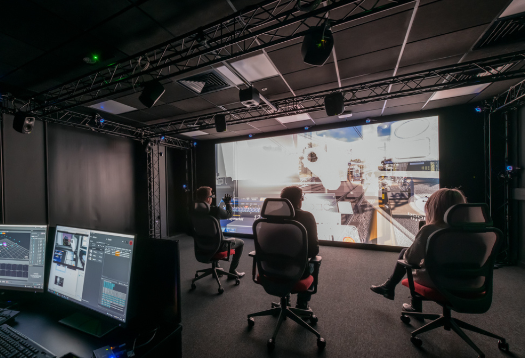 Figure 2 shows three individuals sitting in front of, and interacting with the large-scale virtual reality powerwall in the Digital Innovation Facility. Also referred to as the DIF.