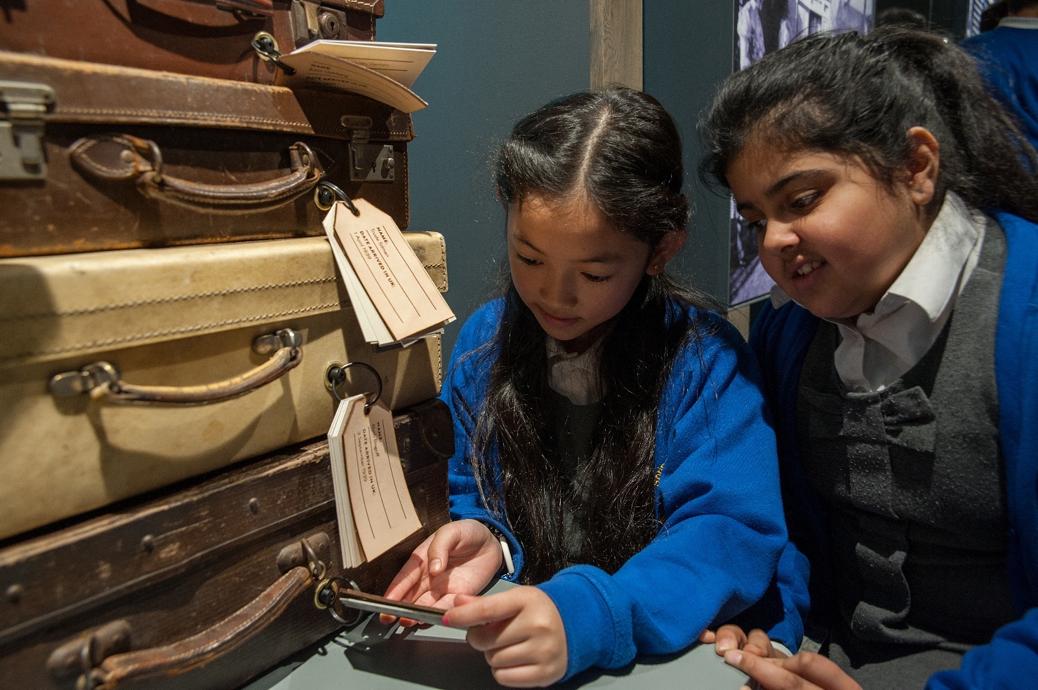 A photograph of two school children reading a suitcase label