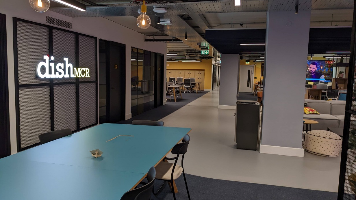 Collaborative Working Space at the DiSH A photograph showing the type of collaborative space at the Digital Innovation Security Hub in Manchester including desk space, individual offices and more informal and social space