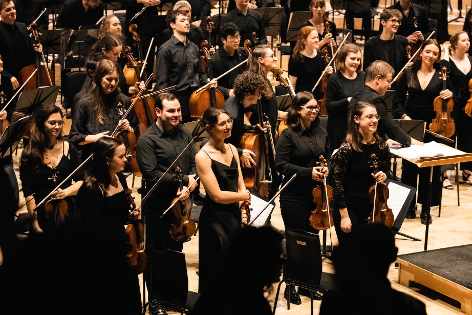 A group of people playing instruments Description automatically generated with medium confidence